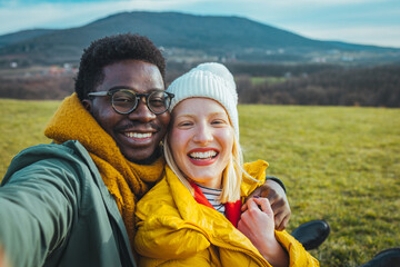 Young Couple Pose For Holiday Selfie. Young couple is hiking in mountain and  They are taking...
