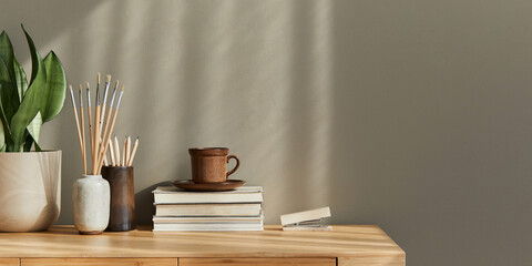 Interior design of neutral bohemian living room interior with stylish desk, lant, book, decoration, office supplies, cup of coffee, copy space, notes and personal accessories. Template.