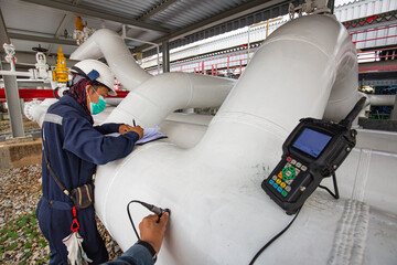 Male worker inspection and measurement thickness pipeline oil and gas at check record pipeline oil.