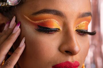 Carnival Party in Brazil, detail of eyeliner and fashion makeup looking down on colorful background