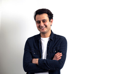 Brown skinned young adult man smiling at camera on isolated white background.