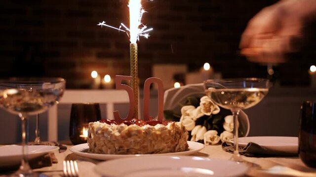 Lighting up a sparkling candle on a birthday cake during the 50 anniversary, celebration concept