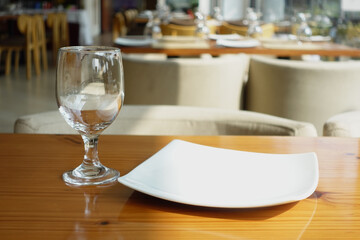 cutlery and empty plate on table against cafe background 