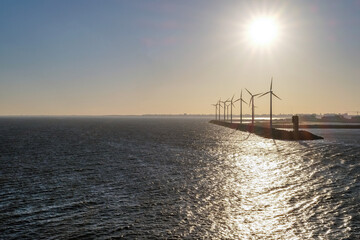 Konzept Energiewende, alternative Energien oder Umweltschutz: Windräder an der Küste in der Abendsonne, sehr viel Copyspace