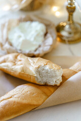 Fresh baguette and cream cheese on the table.