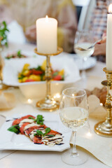 Food, wine and candles on the festive table.