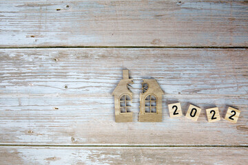 Divorce, division of property, poverty and no money concept. Wooden broken house and New Year 2022 background. Mortgage, rent, realtor