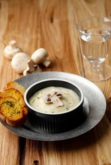 Mushroom Cream  Soup with Crispy Garlic Bread on Wooden Table