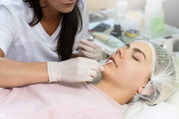 Obraz na płótnie Canvas Professional permanent makeup artist applying anesthetic cream