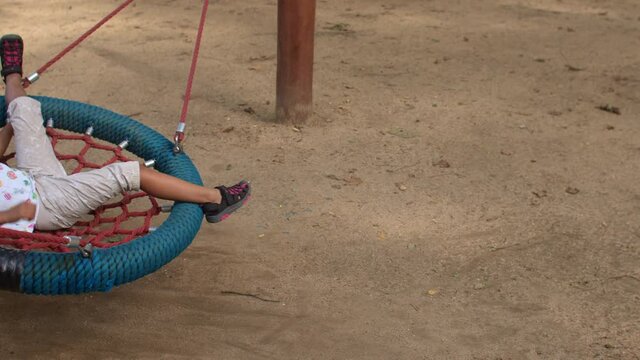 Children play in the playground. The brother is swinging the sister on the swing. The quality of sibling relationships is one of the most important predictors of mental health. 