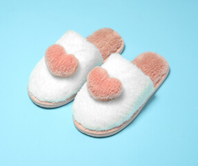 Home soft female slippers pink with white on a blue background.