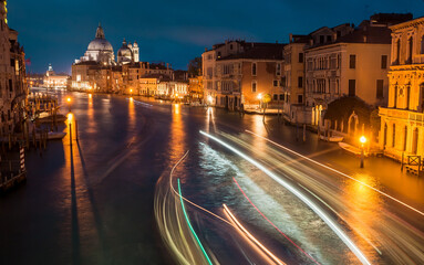 Fototapeta na wymiar Beautiful night city Venice with water canals, riverboats in motion blurs and historical mansions