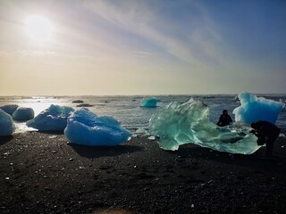 Menschen fotografieren das Eis am Glacier Beach an der S&uuml;dk&uuml;ste von Island