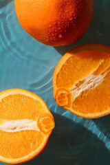 ripe oranges in water on a blue background