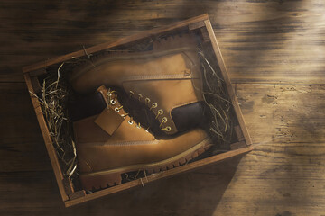 New leather boots inside the wooden box with  hay