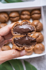 Holding chocolate choux cream with chocolate custard filling