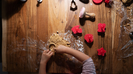 Child making holiday shaped cookies