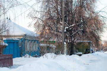 Fototapeta na wymiar Several residential buildings on the snowy street of the village in Russia