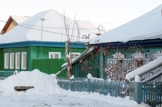 Several residential buildings on the snowy street of the village in Russia