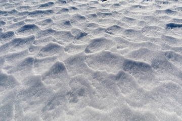 Textured background of a wind-rippled snow surface.