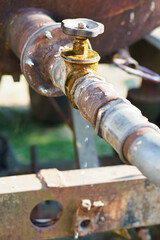Dripping tap of a water tank in the open . Drops fall from the pipe