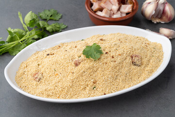 Farofa, typical brazilian manioc flour side dish with seasonings over stone background