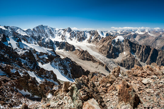 View from the top of Pik Uchitel peak with cross. Ala Archa Alpine National Park Landscape near Bishkek, Tian Shan Mountain Range, Kyrgyzstan, Central Asia.