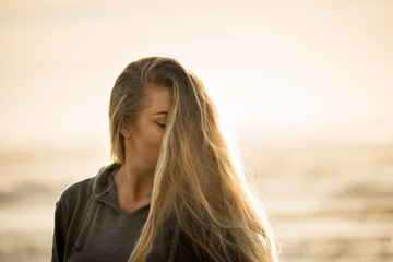 Girl porter outdoors in soft light. The face is half covered with hair.