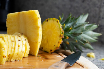 Sliced pineapple on wooden board at kitchen interior