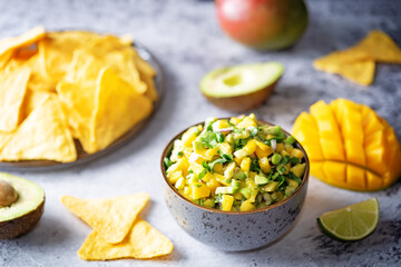 Mango Guacamole with corn chips and ingredients to prepare it