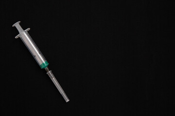 A syringe on a black background. The concept of vaccinations injections and virus protection