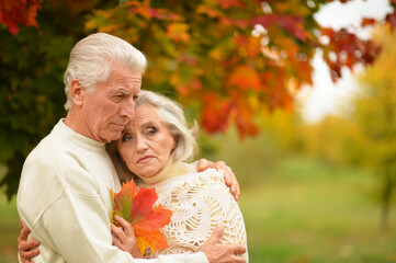 Portrait of sad senior couple in autumn park