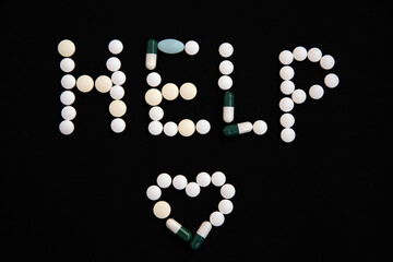 The word help is composed of pills on a black background. The concept of vaccination and health protection