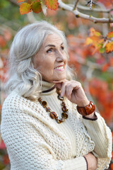 Fototapeta premium Portrait of happy senior woman in autumn park