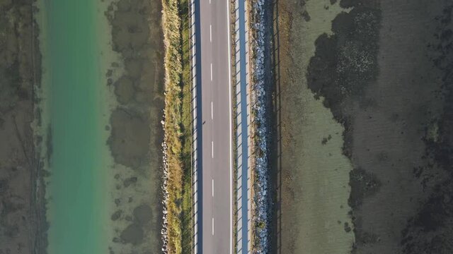 Aerial view of vehicles driving on a beautiful road crossing the lagoon in Grado near Gorizia, Friuli Venezia Giulia, Italy.
