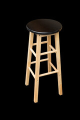Round black wooden chair without a backrest, isolated on black background. (Light from right to left. Shadows appear on the left side of the object.)