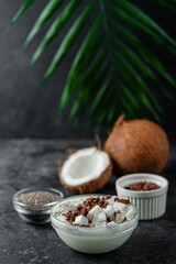 Coconut yogurt with granola and chia on dark background.