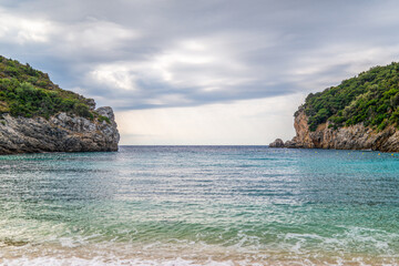 Fototapeta premium Calm beach of Mediterranean sea near high hill with forest