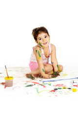 Portrait of gorgeous young girl draws with paints on a white background
