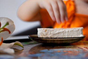 a piece of white cake, cheesecake in a saucer on the table, blue background