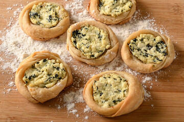 open sfiha filled with ricotta cheese and spinach on a wood