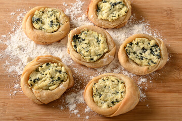 open sfiha filled with ricotta cheese and spinach on a wood