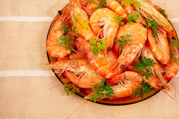 Shrimp beautifully decorated with parsley in a plate on the table, top view, close up