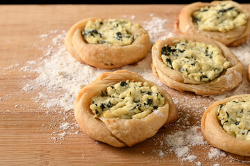 open sfiha filled with ricotta cheese and spinach on a wood
