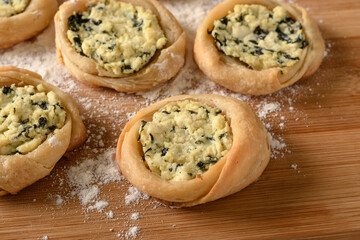 open sfiha filled with ricotta cheese and spinach on a wood