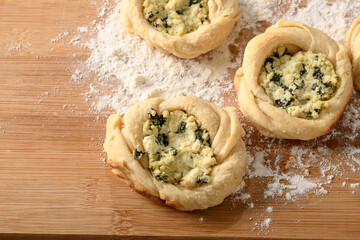 open sfiha filled with ricotta cheese and spinach on a wood