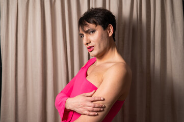 Fototapeta na wymiar Homosexual in a pink female dress. A man in make-up.