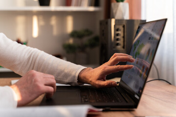 Close up of guy sitting at the table with laptop and working remotely. Stock photo