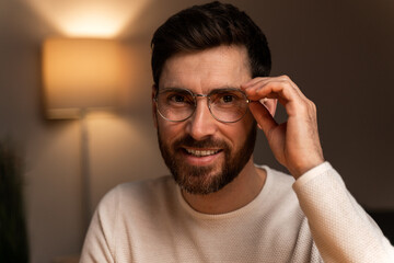 Obraz premium Smiling man wearing spectacles looking at camera. Portrait of confident man at home
