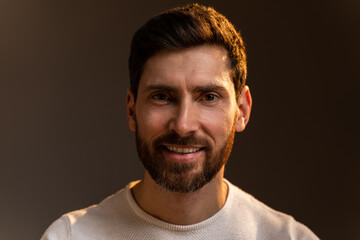 Handsome caucasian man smiling cheery and looking at the camera while spending time at home